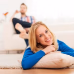 smiling-woman-lying-down-carpet-home_329181-824
